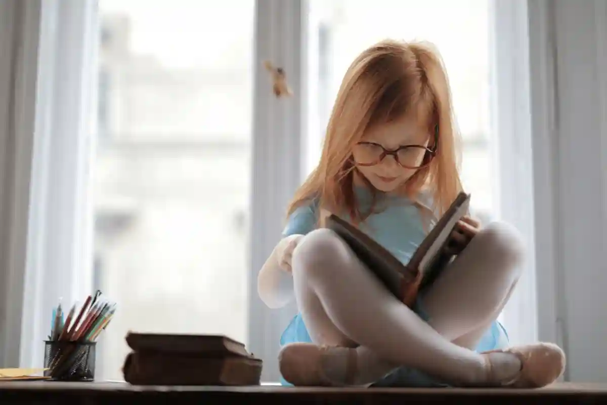 seorang gadis duduk di lantai membaca buku